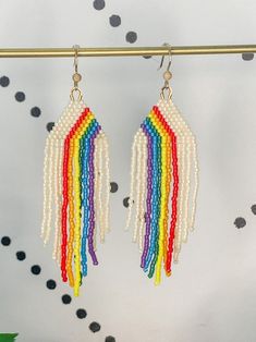 two pairs of multicolored beaded earrings hanging from a hook