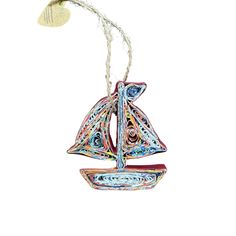 a glass ornament with a sailboat on it's side hanging from a string