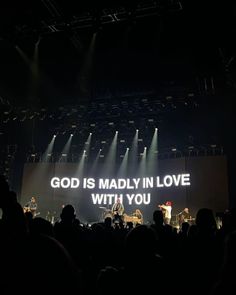 a large screen with the words god is madly in love with you projected on it