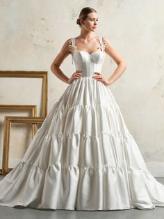 a woman in a white wedding dress posing for the camera