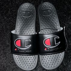 These Champion Slides Are Perfect For Any Activity On The Go. The Slip-On Design Make Them Easy To Put On And Take Off, While The Cushioned Foam Insole Provides Comfort And Support For All-Day Wear. The Water-Resistant And Breathable Synthetic Upper Material And Moisture-Wicking Feature Make Them Suitable For Watersports And Beach Activities. Convenient To Wear Before A Game And Slip On Afterwards. These Athletic Sandals Come In Black Color With Champion Logo Blended In Blk/Grey/Red. They Have A Champion Slides, Champion Shoes, Athletic Sandals, Beach Activities, Champion Logo, Mens Sandals, Water Sports, Flip Flop Sandals, Slide Sandals