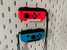 two nintendo wii game controllers hanging on a wall