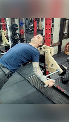 a man with tattoos on his arm working on a bench