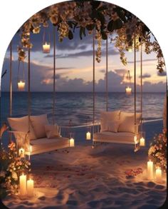 candles are lit on the beach with chairs and flowers in front of the ocean at night