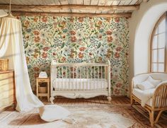 a baby's room with floral wallpaper and white furniture