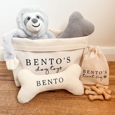 a stuffed animal is sitting in a basket next to some dog treats and a bone