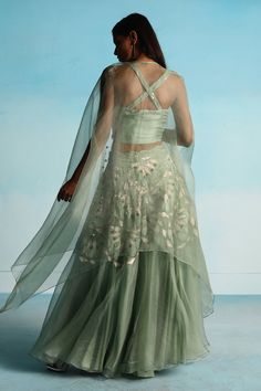 Sage green organza lehenga with applique hand embroidery. Comes with a cape and a pure silk bustier with cord detailing and beaded work.
Components: 3
Pattern: Applique hand embroidered
Type Of Work: Beads
Neckline: Sweetheart
Sleeve Type: Bustier : Sleeveless, Cape : Flared Sleeves
Fabric: Organza, Bustier : 100% Pure silk, Lining : Shantoon
Color: Green
Other Details: 
Cross-back detailing on bustier
Attached lining
Lehenga length : 42 inches
Closure : Bustier - Side zip
Occasion: Sangeet - Az Green Organza Lehenga For Reception, Elegant Pista Green Organza Choli, Green Organza Choli With Intricate Embroidery, Green Organza Sharara With Intricate Embroidery, Floor-length Organza Set With Intricate Embroidery, Pista Green Organza Choli With Sheer Dupatta, Pista Green Organza Lehenga With Resham Embroidery, Designer Wear Pista Green Organza Choli, Anarkali Embellished Organza Sets