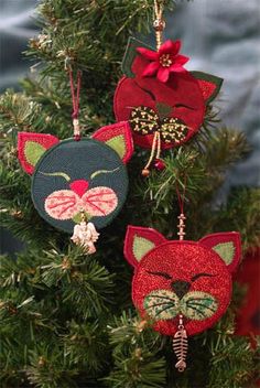 three christmas ornaments hanging from a tree with red and green decorations on it's branches