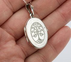 "Also available in gold plated/rose gold plated over sterling silver. This elegant customized oval locket will help you keep the memories of your loved ones afresh: 1. One shining, highly polished sterling silver locket. (19 x 26 mm, about the size of a quarter, 4.6 grams). Its front has an etched decorative border. Its back is plain. Both sides can be custom engraved with initial, text or simple graphics.  2. There are two photo slots. Photo insertion service is available for $14 each photo (pricing reflected in your pulldown option. If you select \" ... 1/2 photo\", please send your locket photos by attaching them to an ETSY conversation to me. 3. a sterling silver or gold filled cross pendant     Upgrade is also available:     https://www.etsy.com/listing/736367470 4. an optional custom Elegant Oval Locket Necklace As A Gift, Elegant Oval Locket Necklace For Gift, Oval Charms Jewelry For Keepsake, Keepsake Oval Charms Jewelry, Oval Keepsake Jewelry With Charms, Oval Keepsake Jewelry Charms, Classic Locket Necklace With Charms For Gift, Elegant Oval Locket Necklace For Personalized Gift, Elegant Medallion Locket Necklace For Personalized Gift