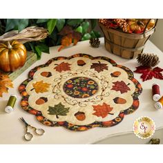 a table topped with lots of different types of fall decorations and sewing supplies on top of it