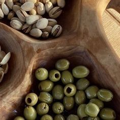 some olives and pistachios in bowls on a table