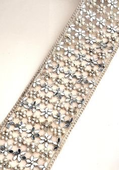 >>Gold Pearl Mirror Embellished Border Flower Pattern Sari Trim  >>8cm Tulle Fabric for Wedding Costume dresses Wedding Sash Belts & Upholstery >> Width -8cm  >> Color-  light gold  >> Material - Tulle , Pearl ,Mirror Perfect for bridal lehengas, sarees, and dupattas, this trim is also a beautiful addition to sash belts, home décor, and upholstered furniture. PLEASE FOLLOW US ON THE FOLLOWING LINKS FOR NEW LAUNCHES 𝐖𝐞𝐛𝐬𝐢𝐭𝐞: www.lacetrimssindia.com 𝐈𝐧𝐬𝐭𝐚𝐠𝐫𝐚𝐦: @lacetrimssindia 𝐏𝐢 Elegant Lace Bridal Belt For Party, Silver Lace With Lace Work For Party, Silver Embellished Lace For Party, Silver Bridal Accessories For Festive Parties, Elegant Embellished Trims For Wedding, Silver Embellished Sash For Party, Silver Embellished Party Sashes, Silver Embellished Sashes For Party, Elegant Embellished Wedding Trims