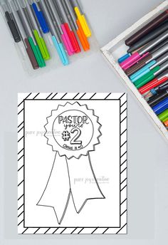 a coloring page with markers and pens on the table next to it is an award