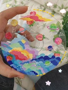 a person holding a glass plate with stickers on it