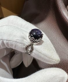 a silver ring sitting on top of a white cloth next to a piece of fabric