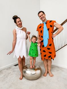 a man, woman and child dressed up as the flint family posing for a photo