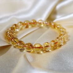 This beautiful 9mm Rainbow Citrine bracelet is the perfect gift to spark joy and beauty in someone's life. It is made from the highest quality crystal and is perfect for home decor, healing crystal, and gifting. The soft rainbow hues of this Rainbow Citrine bracelet will take your breath away. The iridescent tones of this lovely crystal warmly embrace you and make you feel secure in knowing that life has a plan for you that will be infinitely beautiful. Not only does it bring peace to your soul, but it also radiates amazing energies far beyond what you can see, allowing its healing properties to protect your physical, emotional, and spiritual wellbeing. Rainbow Citrine is known as one of the most powerful crystals of abundance and prosperity. It encourages you to manifest your ideal realit Luxury Yellow Gemstone Bracelet, Citrine Bracelet, Citrine Jewelry, Power Crystals, Spark Joy, Citrine Crystal, November Birthstone, Deep Colors, Crystal Gifts