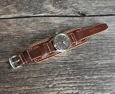 Leather cuff watch band Brown of High quality for men. Compatible with watch case 18mm 20mm 22mm 24mm. It has a beautiful dark brown color with a slight shine and vintage effect. From the touch of your hands, the strap will darken over time and become covered with patina, this will give the strap more individuality and beauty.
Horween leather watch strap is unique. Due to the peculiarity of the leather from which the strap is made, there cannot be two such identical straps. 
Handmade bund band is durable, soft, elastic with a pleasant texture to the touch. It will surely serve you for many years. The Bund, Military Design, Horween Leather, Vintage Effect, Cuff Watch, Band Pictures, Dark Brown Color, Leather Watch Strap, Leather Cuffs