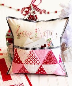 a decorative pillow that says love note on the front and back with an envelope inside