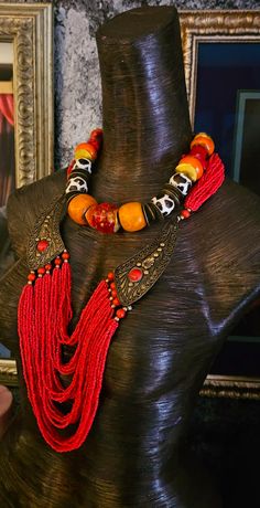 Here's a Bohemian Necklace and Bib Set I found in my inventory. The longer strand is a vintage piece that I did not make. It measures a non-adjustable 28" and closes with a button and a loop. Multiple strands of red-orange seed beads comprise the majority of the piece and two ornate metal accents (looks like bronze) are symmetrically set on each side with an orange-red cabochon (jade??). The shorter necklace is one that I made. It measures a non-adjustable 19" and features the following components: Tibetan resin, Moroccan resin, Zebu bone*, gold tone metal spacers, vintage Chinese brass coins, red branch corals, vintage brass beads and round tiger's eye. Closes with a gold tone hook and eye. Pair them together, or wear separately. These also will mix and match well with your personal favor Vintage Style Polished Beads Necklace, Vintage Hand-strung Beaded Necklaces For Festivals, Vintage Hand-strung Beaded Necklace For Festivals, Adjustable Vintage Beads For Festival, Vintage Multi-strand Beaded Necklaces, Vintage Adjustable Beaded Necklaces For Festivals, Adjustable Vintage Beaded Necklace For Festivals, Vintage Multi-strand Beaded Necklace, Vintage Adjustable Hand-strung Beaded Necklaces