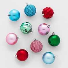 christmas ornaments are arranged in different colors and sizes on a white surface, top view