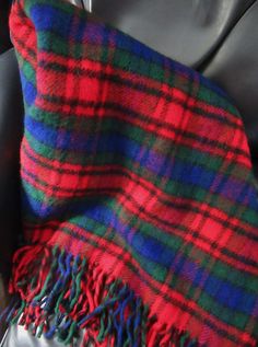 a red, green and blue plaid blanket sitting on top of a couch