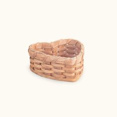 a small wooden basket sitting on top of a white surface