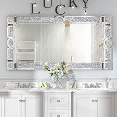 a bathroom with two sinks and a large mirror over the sink that says lucky on it