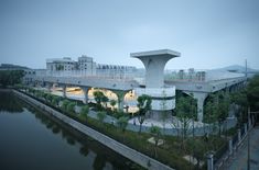 the building is next to a body of water with trees on both sides and buildings in the background