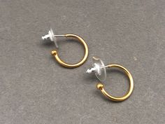 Gold plated Mini Creole Earrings. The hoop is 1cm diameter. The earrings are made from brass, and the posts are sterling silver. ------------------------------------------ You may also be interested in -  Our Recycled Glass and Gold Circle Earrings:  https://www.etsy.com/uk/listing/524538124/green-recycled-glass-gold-hoop-drop?ref=shop_home_active_4 Our Malachite and Gold Circle Earrings:  Our Recycled Glass Ball Pendant:  https://www.etsy.com/uk/listing/523202258/recycled-glass-ball-pendant-nec Gold Hoop Plug Earrings As Gift, Gold Hypoallergenic Hoop Plug Earrings, Hypoallergenic Small Hoop Gold Plug Earrings, Adjustable Gold Wrap Single Earring, Adjustable Single Gold Wrap Earring, Gold Hoop Plug Earrings, Gold Small Hoop Plug Earrings For Everyday, Small Hoop Gold Plug Earrings, Gold Round Wrap Earrings