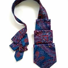 a purple and blue paisley tie with a matching bow on the end, against a white background