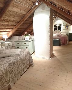 an attic bedroom with wooden floors and white walls