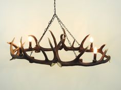 a deer antler chandelier with six candles hanging from it's center