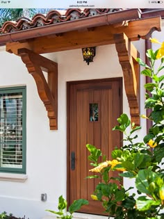 a white house with green shutters and a wooden door