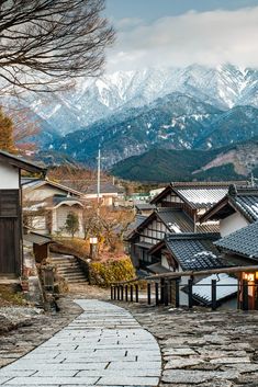 an old village with mountains in the background and snow - capped peaks on the horizon