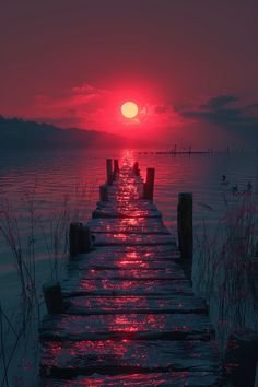 the sun is setting over the water on a pier