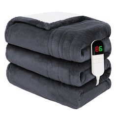 three blankets stacked on top of each other with an electronic thermometer attached to them