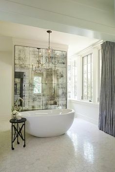 a bathroom with a large bathtub and chandelier