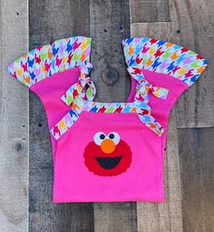 Elmo Summer 1 Piece Romper Outfit This cute boutique Elmo romper outfit would be perfect for a Sesame Street Elmo theme birthday party, or just a fun day out in the sun. Outfit is hot pink knit trimmed in a rainbow houndstooth print with an Elmo applique on front. Elmo Sesame Street Theme 100% Stretch Knit/Cotton Wash Warm tumble dry low iron if needed HANDMADE IN USA Playful Pink Tops For First Birthday, Playful Pink Top For First Birthday, Pink Fun Tops For Playdate, Fun Pink Tops For Playdate, Cute Summer Tops For Daycare, Sun Outfit, Bug Clothing, Elmo Sesame Street, Sesame Street Elmo