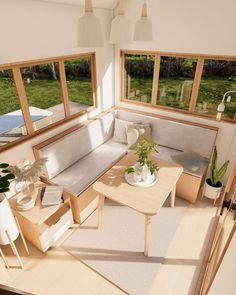 a living room filled with lots of furniture and plants on top of a wooden table