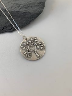 This unique Tree of Life handmade embossed round pendant has been entirely handmade using .999 fine silver. It has been cut from fine silver precious metal clay, textured, fired and oxidized. The pendant hangs from a sterling silver diamond cut cable chain. This fine silver pendant features an embossed Tree of Life image on one side of the pendant and is reversible to a tiny leaves embossed pattern on the reverse side. Pendant size: approximately 3/4 x 3/4 inches Chain length: adjustable at 16 a Moon Necklace Silver, Tree Of Life Earrings, Silver Bar Necklace, Metal Clay Jewelry, Layered Necklaces Silver, Pendant Necklace Silver, Precious Metal Clay, Unique Trees, Charm Necklace Silver