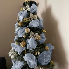 a blue christmas tree decorated with gold and silver ornaments