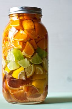 a jar filled with sliced oranges and limes