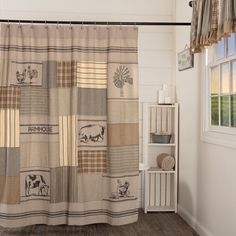 a bathroom with a shower curtain and wooden flooring next to a window in the wall