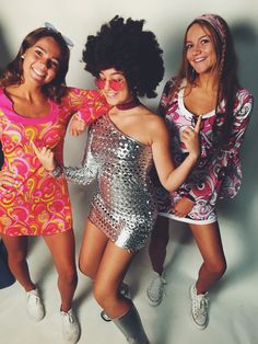 three women in disco outfits posing for the camera