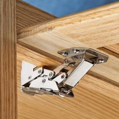 a pair of metal hinges attached to a wooden door