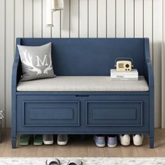 a blue bench with shoes on it in front of a white wall and wooden floor