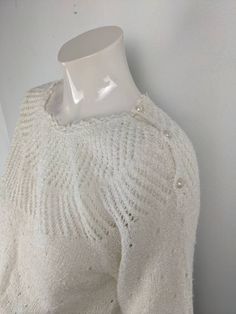 a white sweater on a mannequin neckline, with buttons at the back