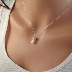 This bridal necklace is a perfect choice for a traditional wedding, where the bride wants just a touch of colour. Its pink and ivory colour combination is romantic, and reminiscent of Valentine's Day. Sterling silver cable chain extends down to a glowing freshwater drop pearl. This pearl is smooth, with beautiful luster. The cluster on top of the pearl includes tiny keishi pearls, genuine rubies and rose quartz. Very feminine, this necklace is a little splash of soft colour on your wedding day.T Elegant Pink Pearl Drop Necklace, Elegant Pink Pearl Charm Jewelry, Elegant Pink Pearl Jewelry, Feminine Silver Pearl Necklace For Wedding, Feminine Pearl Pendant Jewelry For Wedding, Feminine Pearl Necklace For Wedding, Feminine Rose Gold Wedding Necklaces, Feminine Rose Gold Necklaces For Weddings, Elegant Pink Bridal Necklace For Wedding