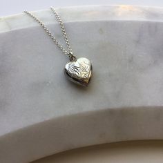 Vintage silver heart pendant on chain.This vintage silver heart shaped pendant features engraving on the front with a plain back. There are also the initials 'FJW' engraved on the top corner of the pendant. There is a small dent near the edge on the back (see photograph). Comes on a modern sterling silver 18" chain or with no chain, please select which from the dropdown box.Marked 'SILVER' on the reverse.Locket measures 1.5cm wide, 1.6cm high, 0.5cm deep.The necklace will come beautifully presen Silver Double Heart Locket Necklace, Silver Heart Pendant Locket Necklace, Sterling Silver Open Heart Keepsake Necklace, Silver Heart Locket Necklace For Anniversary, Silver Heart Cut Locket Necklace For Anniversary, Silver Heart-shaped Locket Necklace For Anniversary, Silver Necklace With Polished Double Heart, Silver Double Heart Necklace With Polished Finish, Sterling Silver Heart Pendant Locket Necklace For Keepsake